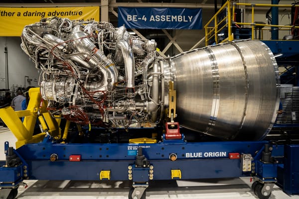 A rocket engine lays horizontally on a flatbed structure with wheels, ready to be transported.